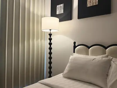 a bedroom with a bed with a lamp and curtains at Cozy Unit l Agile BB l 5min walk to TRX Pavilion in Kuala Lumpur