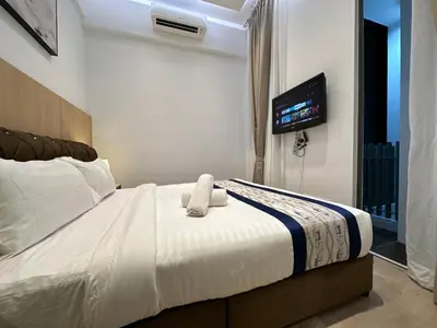 a bedroom with a bed with a tv on the wall at Vortex Suites Klcc by BEST TO BEST in Kuala Lumpur