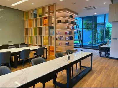 a room with tables and chairs and a book shelf at One Star KLCC in Kuala Lumpur