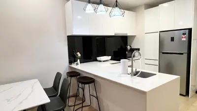 a kitchen with white counters and a sink and a refrigerator at One Star KLCC in Kuala Lumpur