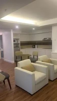 a living room with couches and chairs and a kitchen at RaarFAM Homestay in Kuala Lumpur