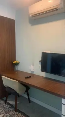 a wooden table with a television on a wall at RaarFAM Homestay in Kuala Lumpur
