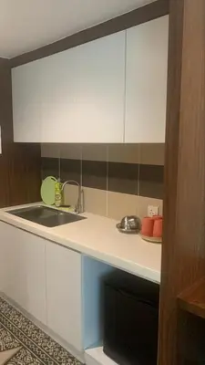 a kitchen with white cabinets and a sink at RaarFAM Homestay in Kuala Lumpur