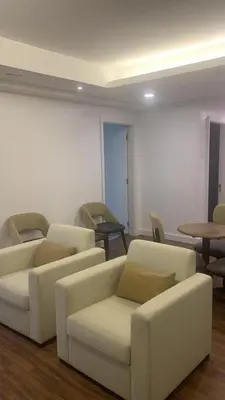 a living room with white couches and tables at RaarFAM Homestay in Kuala Lumpur