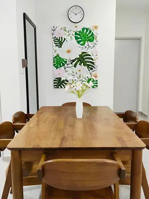 a dining room table with a vase of flowers on it at Inap KL in Kuala Lumpur