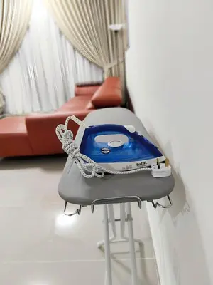 a iron on a table in a room with a couch at Inap KL in Kuala Lumpur