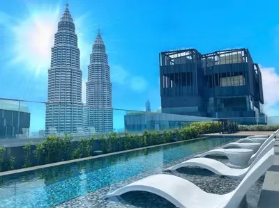 a pool with a view of the petronas twin towers at One Star KLCC in Kuala Lumpur