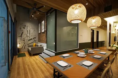 a dining room with a large wooden table with chairs at Chaos Boutique Hotel Kuala Lumpur in Kuala Lumpur