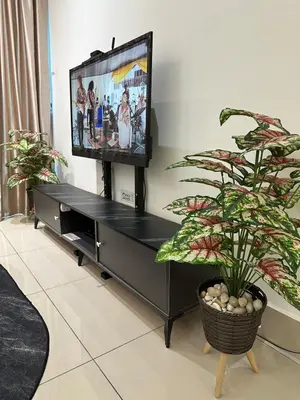 a black entertainment center with a flat screen tv at Anaqi Homestay by Razak City Sg Besi in Kuala Lumpur