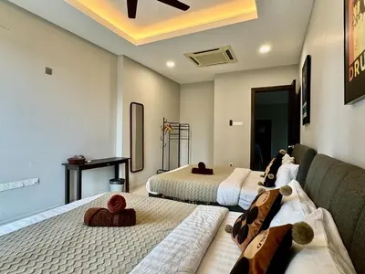 a hotel room with two beds and a couch at B3A l KLCC TRX Contemporaryl 17 Pax in Kuala Lumpur