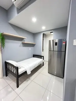 a small room with a bed and a refrigerator at Robertson suites At Bukit Bintang South Lobby in Kuala Lumpur