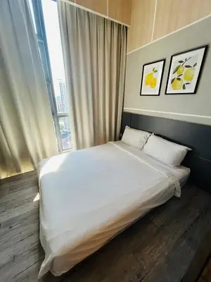 a bedroom with a large white bed with a window at Robertson suites At Bukit Bintang South Lobby in Kuala Lumpur