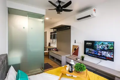 a living room with a couch and a tv on the wall at 24H Check in & Skypool - Riveria City Premium KL Suite in Kuala Lumpur