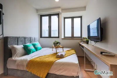 a bedroom with a bed and a tv and windows at 24H Check in & Skypool - Riveria City Premium KL Suite in Kuala Lumpur