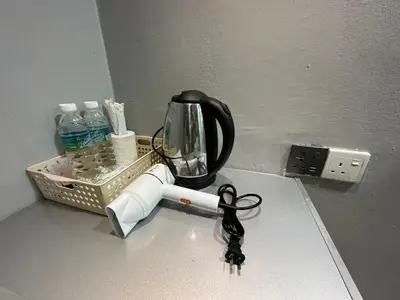 a kitchen counter with a coffee maker and a light switch at SS Grey Hotel kL in Kuala Lumpur