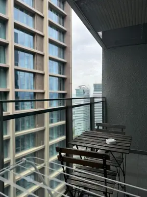 a balcony with a wooden table and chairs on a building at Summer Suite KL City Balcony Room KL Tower View in Kuala Lumpur