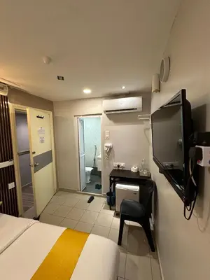 a bedroom with a bed and a desk and a television at SS Grey Hotel BB in Kuala Lumpur
