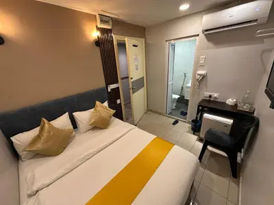 a bedroom with a bed and a desk and a bathroom at SS Grey Hotel BB in Kuala Lumpur