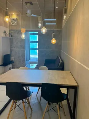 a table in a room with chairs and lights at Robertson Special Suites By Luna in Kuala Lumpur
