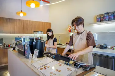 a man and woman preparing food in a kitchen at Neu Suites KL with Daily Breakfast Included in Kuala Lumpur