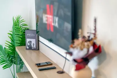 a shelf with a tv and a book and a plant at Neu Suites KL with Daily Breakfast Included in Kuala Lumpur