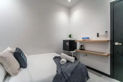 a small room with a bed and a desk at Neu Suites KL with Daily Breakfast Included in Kuala Lumpur