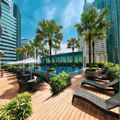 a pool with benches and palm trees in a city at Vortex klcc by Elham in Kuala Lumpur