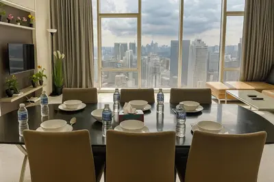 a dining room with a table and chairs and a large window at Eastern Suites AT Platinum KLCC in Kuala Lumpur