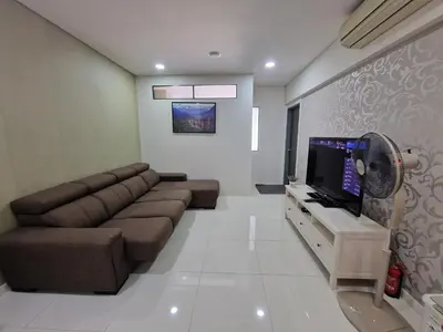 a living room with a couch and a flat screen tv at Summer Suites Klcc 2BR Apartments by ATIQ in Kuala Lumpur