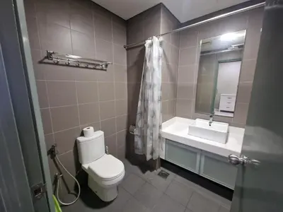 a bathroom with a toilet and a sink and a mirror at Summer Suites Klcc 2BR Apartments by ATIQ in Kuala Lumpur