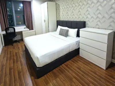 a bedroom with a white bed and a desk at Summer Suites Klcc 2BR Apartments by ATIQ in Kuala Lumpur
