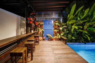 a restaurant with a blue door and some plants at 68 Palms 03 l Midvalley l KL Sentral in Kuala Lumpur