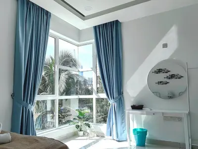 a bedroom with blue curtains and a large window at A3A l Near KLCC TRX l Santorini l 18 Guests in Kuala Lumpur