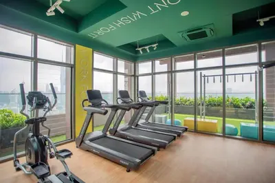 a gym with treadmills and ellipticals in a room with windows at Cozy Studio l Riveria City l 1km to KL Sentral in Kuala Lumpur