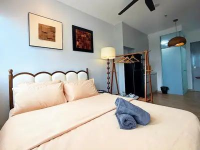 a bedroom with a large white bed with a blue wall at Cozy Studio l Riveria City l 1km to KL Sentral in Kuala Lumpur