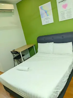 a bed in a room with a green wall at Sky Suites KLCC Kuala Lumpur LB in Kuala Lumpur