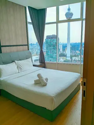 a bed in a room with a large window at Sky Suites KLCC Kuala Lumpur LB in Kuala Lumpur
