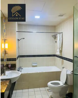 a bathroom with a tub and a toilet and a sink at Ceylon Stay in Kuala Lumpur