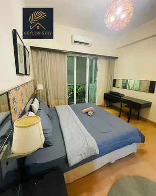 a bedroom with a large bed and a desk at Ceylon Stay in Kuala Lumpur