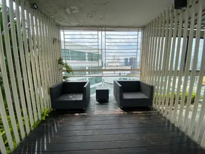 a balcony with two chairs and a large window at CloudNest Infinity Sky pool Hostel in Kuala Lumpur