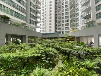a garden in the middle of a building with tall buildings at CloudNest Infinity Sky pool Hostel in Kuala Lumpur
