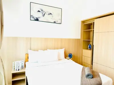a bedroom with a white bed and a book shelf at The Luxe & Colony KLCC By Comfort Dwellings in Kuala Lumpur