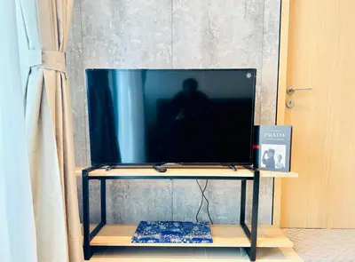 a flat screen tv on a tv stand at The Luxe & Colony KLCC By Comfort Dwellings in Kuala Lumpur
