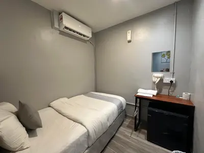 a small room with two beds and a desk with a phone at SS GREY HOUSE Jalan Alor in Kuala Lumpur