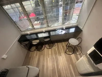an attic room with a large window and chairs at SS GREY HOUSE Jalan Alor in Kuala Lumpur