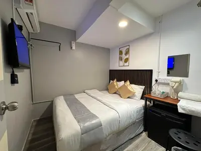 a bedroom with a bed and a desk and a television at SS GREY HOUSE Jalan Alor in Kuala Lumpur
