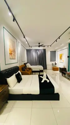 a bedroom with a large bed and a living room at chamber suites by bintang in Kuala Lumpur