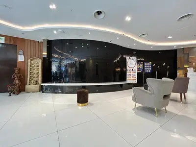 a lobby with two chairs and a stage in a building at Kingston Hotel by Minsu in Kuala Lumpur