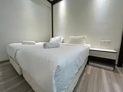 a white bed with white sheets and pillows on it at Kingston Hotel by Minsu in Kuala Lumpur
