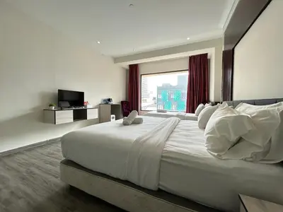 a bedroom with a large white bed with a large window at Kingston Hotel by Minsu in Kuala Lumpur